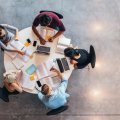 an aerial view of five people sitting at a table with laptops and open books